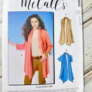 Könnte beinhalten: Ein McCall's Schnittmuster mit einer Frau in einem korallenfarbenen Cardigan. Das Muster enthält Illustrationen einer beigefarbenen Weste und eines blauen Kurzarm-Cardigans. Der Text "#JanisMcCalls" ist ebenfalls sichtbar.