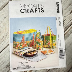 May include: McCall's Crafts sewing pattern M6338 featuring various fabric projects. The projects include a casserole carrier, wine bottle tote, and tote bags. The pattern includes the text "twenty thirty minutes to sew".
