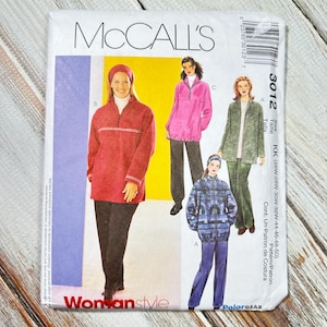 May include: A McCall's sewing pattern envelope featuring illustrations of women's clothing designs. The envelope displays a red, pink, and green top with black pants. The text "Womanstyle" is visible.
