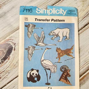 May include: Vintage Simplicity transfer pattern featuring illustrations of various animals, including a polar bear, panda, and crane, on a blue background. The pattern is designed to benefit the World Wildlife Fund.