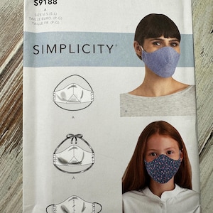 May include: A Simplicity sewing pattern for making face masks. The pattern includes instructions for making two styles of masks: one with ties and one with elastic. The pattern is for sizes S-L.
