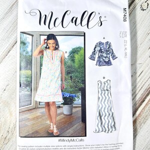 May include: A white sewing pattern from McCall's, featuring a woman in a sleeveless dress and two other garment designs. The pattern includes the text "#MindyMcCalls" and is designed and printed in the USA. Size ZZ (L-XL-XXL).