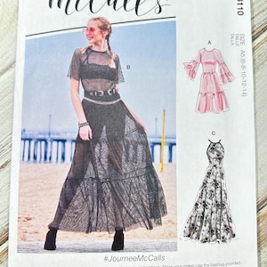 Pode incluir: Padrão de costura McCall's M8110 com designs de vestidos. O padrão mostra uma mulher com um vestido preto transparente e ilustrações de um vestido rosa e um vestido floral. Tamanho A5 (6-8-10-12-14).