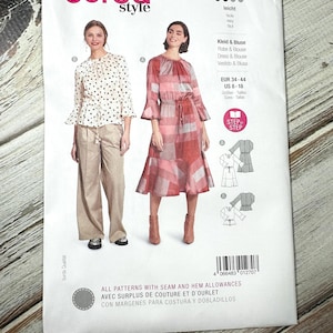 Op de afbeelding: Een Burda Style naaipatroon voor een jurk en blouse, met maten EUR 34-44 en US 8-18. De patroonhoes toont afbeeldingen van de afgewerkte kledingstukken. De tekst op de hoes is in meerdere talen.