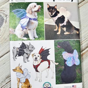 Könnte beinhalten: Simplicity Schnittmuster S9875 mit Hunde-Kostümen mit Flügeln und Schmetterlingsdesigns. Das Muster enthält verschiedene Größen und ist in den USA entworfen und gedruckt.