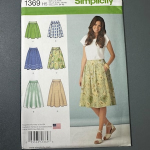 May include: Simplicity sewing pattern 1369 H5 featuring skirt designs. The pattern includes illustrations of various skirt styles in green, blue, and floral prints. The cover shows a woman wearing a floral skirt. The pattern size is U.S. 6-14.
