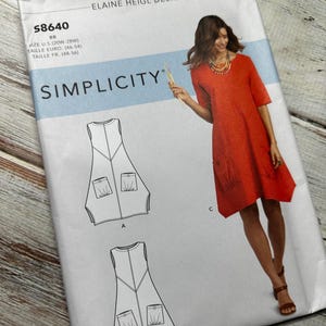 May include: Simplicity sewing pattern number 58640 for a sleeveless dress with pockets. The pattern includes three different styles: A, B, and C. The model is wearing style C, a red dress with a scoop neck and three-quarter sleeves.