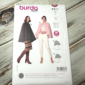 May include: A white sewing pattern package with the "burda style" logo and the number 6063. The package shows illustrations of capes and includes size information in UK and European measurements. The package has images of women wearing capes.