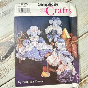 May include: Simplicity Crafts sewing pattern featuring four mouse dolls in various outfits. The pattern cover includes the text "7590 ONE SIZE" and "by Faith Van Zanten". The dolls are seated on miniature chairs with cheese and apples.