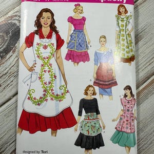 以下が含まれることがあります： Simplicityのソーイングパターン8827は、エプロンのデザインが特徴です。 パターンの表紙には、花柄や模様のエプロンなど、さまざまなエプロンのスタイルのイラストが描かれています。 このパターンはTeriによって設計され、1927年から製造されています。