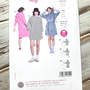 May include: A Burda Easy sewing pattern with three dress designs. The pattern shows a pink hooded dress, a black and white striped dress, and a blue hooded dress. Sizes are EUR 34-48 and US 8-22. The text reads 'super easy'.