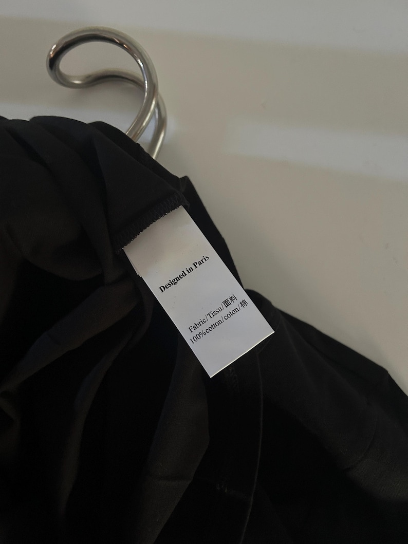 May include: A white tag with black text that reads "Designed in Paris" and "Fabric/Tissu/面料 100%cotton/coton/棉".