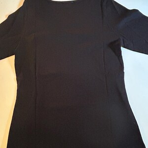 May include: A black long-sleeved shirt with a scoop neck.