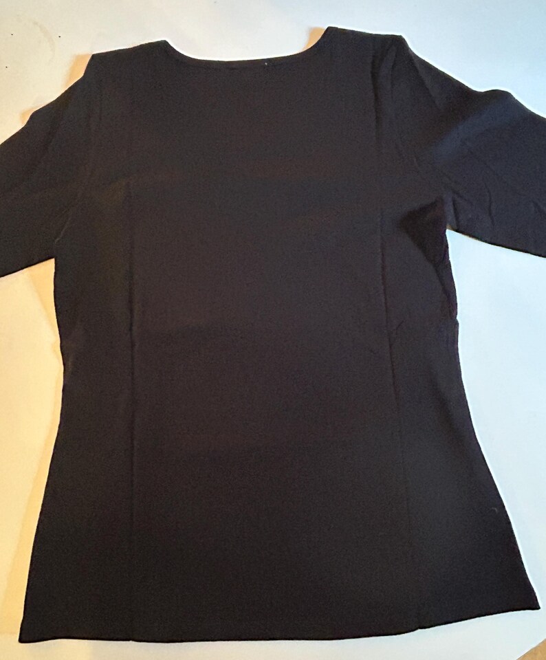 May include: A black long-sleeved shirt with a scoop neck.