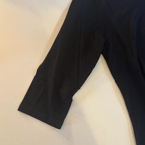 May include: A black long-sleeved shirt with a round neckline.