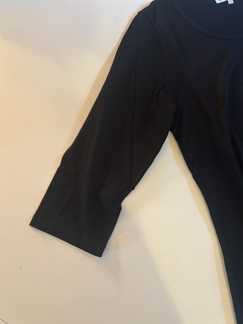 May include: A black long-sleeved shirt with a round neckline.