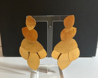 Op de afbeelding: Een paar gouden oorbellen met een cascade-ontwerp van vijf overlappende, getextureerde, blaadjesvormige stukken.