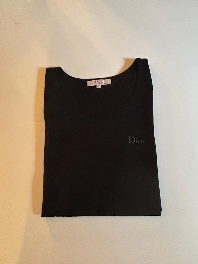 May include: Black t-shirt with a small embroidered "Dior" logo on the front.