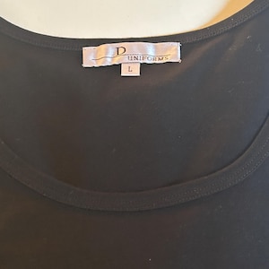 May include: Black sleeveless shirt with a white tag that reads "D UNIFORMS" and a size "L" label.