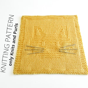 Pode incluir: Um pano de prato de malha amarelo com um design de rosto de gato. Os bigodes do gato são feitos de agulhas de tricô.