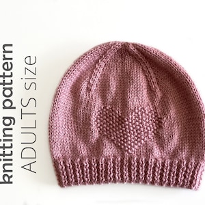 May include: A pink knitted hat with a heart design. The hat is made with a soft yarn and has a simple, classic style.