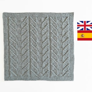 May include: A square knitted blanket in a light gray color with a repeating pattern of diagonal lines. The blanket has a textured, woven look.