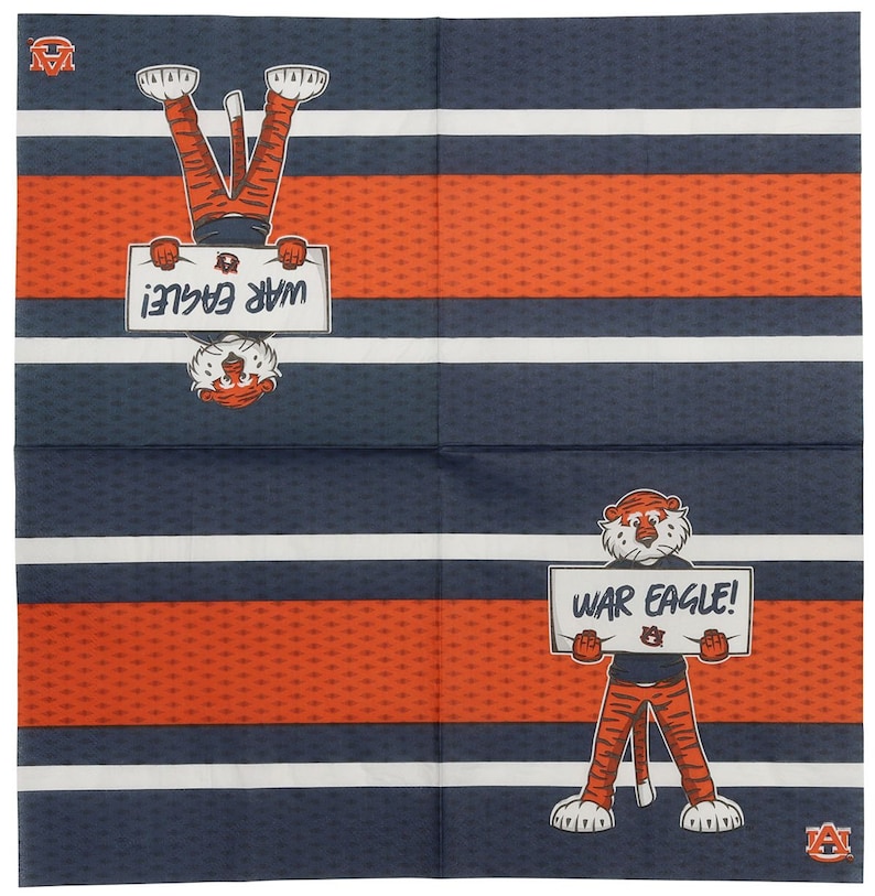 May include: A set of four blue and white striped napkins with an orange pattern. Each napkin features a cartoon tiger holding a sign that says "War Eagle!" The tiger is wearing blue jeans and a white shirt with an orange logo. The napkins are perfect for a game day party or tailgating.