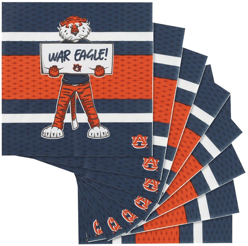 May include: A pack of 10 blue and orange napkins with a cartoon tiger holding a sign that says "War Eagle!" The tiger is wearing orange pants and a blue shirt with the Auburn University logo. The napkins have a white stripe pattern.