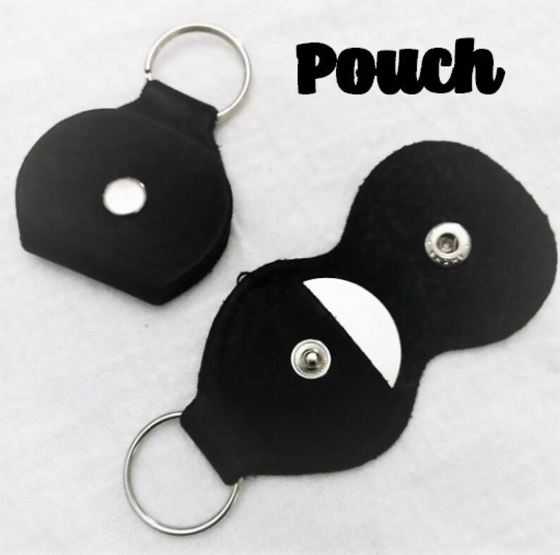 May include: Two black leather pouches with snap closures. One pouch has a key ring and the other has a small pocket for a guitar pick. The text "Pouch" is printed in white on a black background.