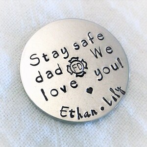 May include: Silver round keychain with the text "Stay safe dad We love you! Ethan. Lily" and a firefighter symbol.