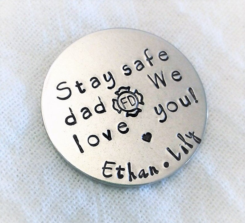May include: Silver round keychain with the text "Stay safe dad We love you! Ethan. Lily" and a firefighter symbol.