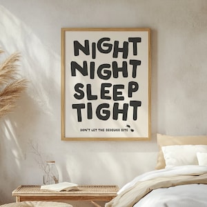 May include: Black and white typography print with the text "Night Night Sleep Tight" and the words "Don't Let The Bedbugs Bite" below. The print is framed in a light wood frame and is hanging on a white wall.
