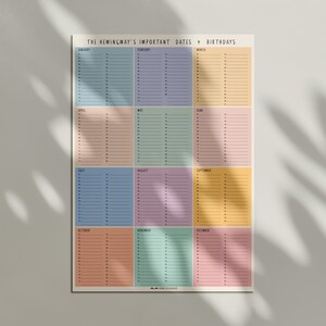 May include: A colorful wall calendar titled "THE HEMINGWAY'S IMPORTANT DATES + BIRTHDAYS." The calendar features twelve months, each in a different pastel color, with dates listed in columns. The design is minimalist and modern, suitable for home or office.