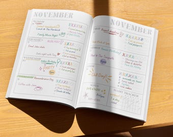 Puede incluir: Una agenda abierta que muestra el mes de noviembre con entradas manuscritas, listas de tareas y rastreadores de hábitos. Las páginas presentan secciones diarias de lunes a domingo, incluyendo notas y tareas específicas escritas con tintas de colores.