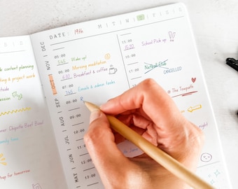 May include: A white daily planner page with black printed hourly time slots from 05:00 to 14:00. The planner features handwritten notes in various colored inks, including tasks like Wake up, Morning meditation, Breakfast and coffee, and Netball Club.