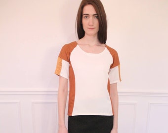 Short sleeve blouse with contrasting cut-outs. White and saffron