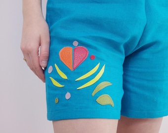 Pantalón corto de lino azul con aplicaciones.