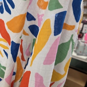 fabric held up to show semi sheer woven. fashion fabric by the yard. fabric perfect for dresses, skirts, shirts, blouses.