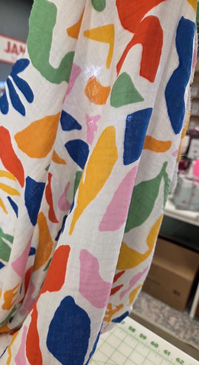 fabric held up to show semi sheer woven. fashion fabric by the yard. fabric perfect for dresses, skirts, shirts, blouses.