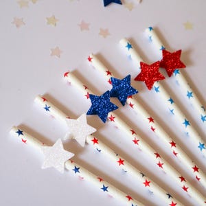 May include: Set of six red, white, and blue paper straws with glitter stars. The straws are decorated with red and blue stars on a white background.