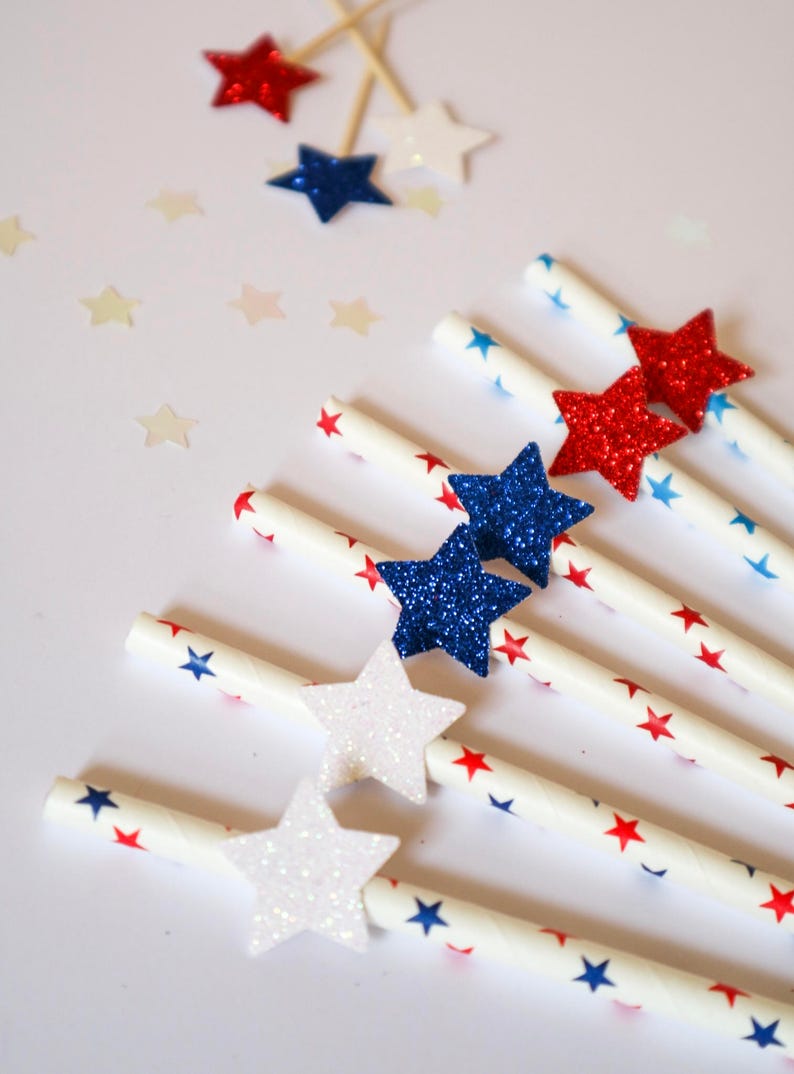 May include: White paper straws with red, blue, and white glitter stars. The straws are decorated with red and blue stars.