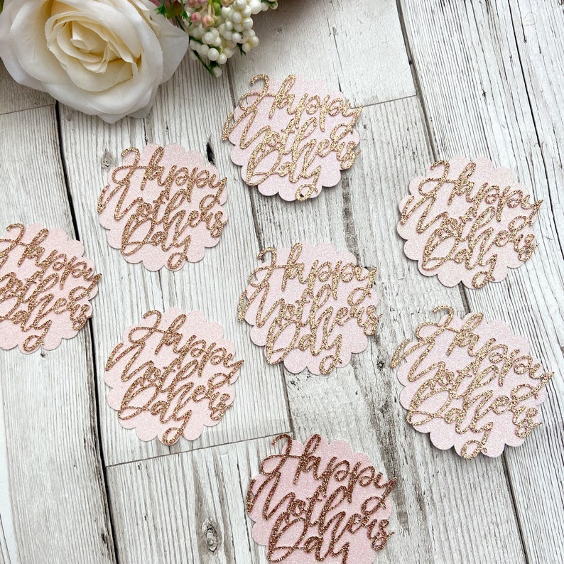 Puede incluir: Confetti de purpurina rosa y dorada con el texto "Happy Mother's Day" en cada pieza.