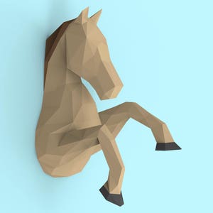 May include: A brown papercraft horse sculpture with black hooves. The horse is in a sitting position with its legs bent and its head tilted to the side.