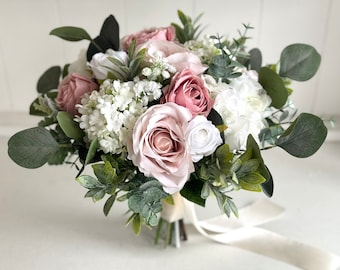 Pode incluir: Um buquê de noiva em rosa e branco com rosas, hortênsias e folhagem.
