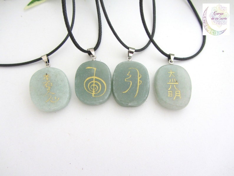 May include: Four green stone pendants with black cords and silver clasps. Each pendant has a different gold symbol or characters. The symbols are "木火土金水", "生命", "气", and "太极".