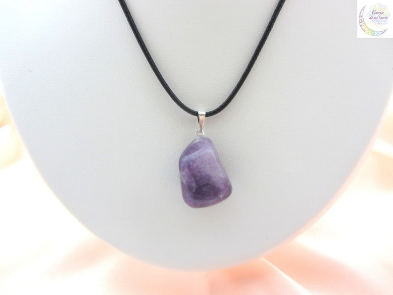 May include: A polished, irregular purple amethyst gemstone pendant suspended from a simple black cord necklace. The stone features natural color variations and is attached to the cord with a small, silver-toned metal bail.