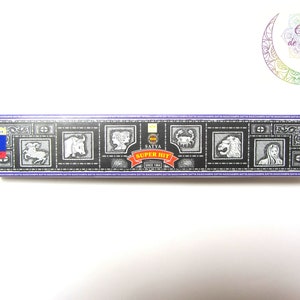 Peut inclure: Une boîte noire et violette de bâtonnets d'encens Satya Super Hit. La boîte présente un motif de symboles du zodiaque et le texte "Satya Super Hit Since 1984".