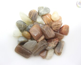 May include: A collection of sunstone tumbled stones in various shades of brown, orange, and white. The stones are smooth and polished, with a natural, iridescent sheen.