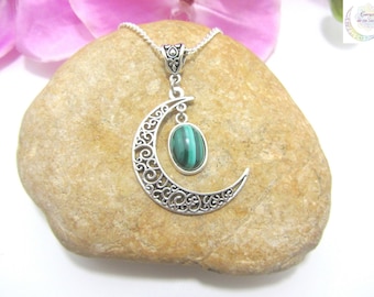 May include: A silver crescent moon pendant necklace with a green malachite stone. The pendant is detailed with intricate filigree work.