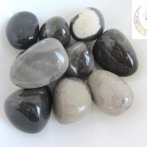 以下が含まれることがあります： 灰色と黒の色の滑らかで磨かれた石の9つのコレクション。石はさまざまなサイズと形であり、一部は白い大理石の効果があります。